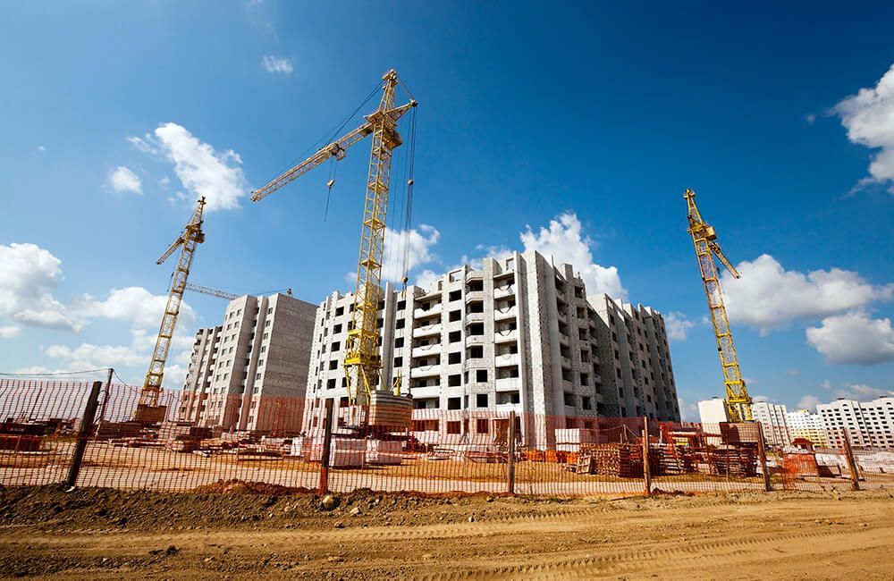 A large building is being built with cranes in the foreground.