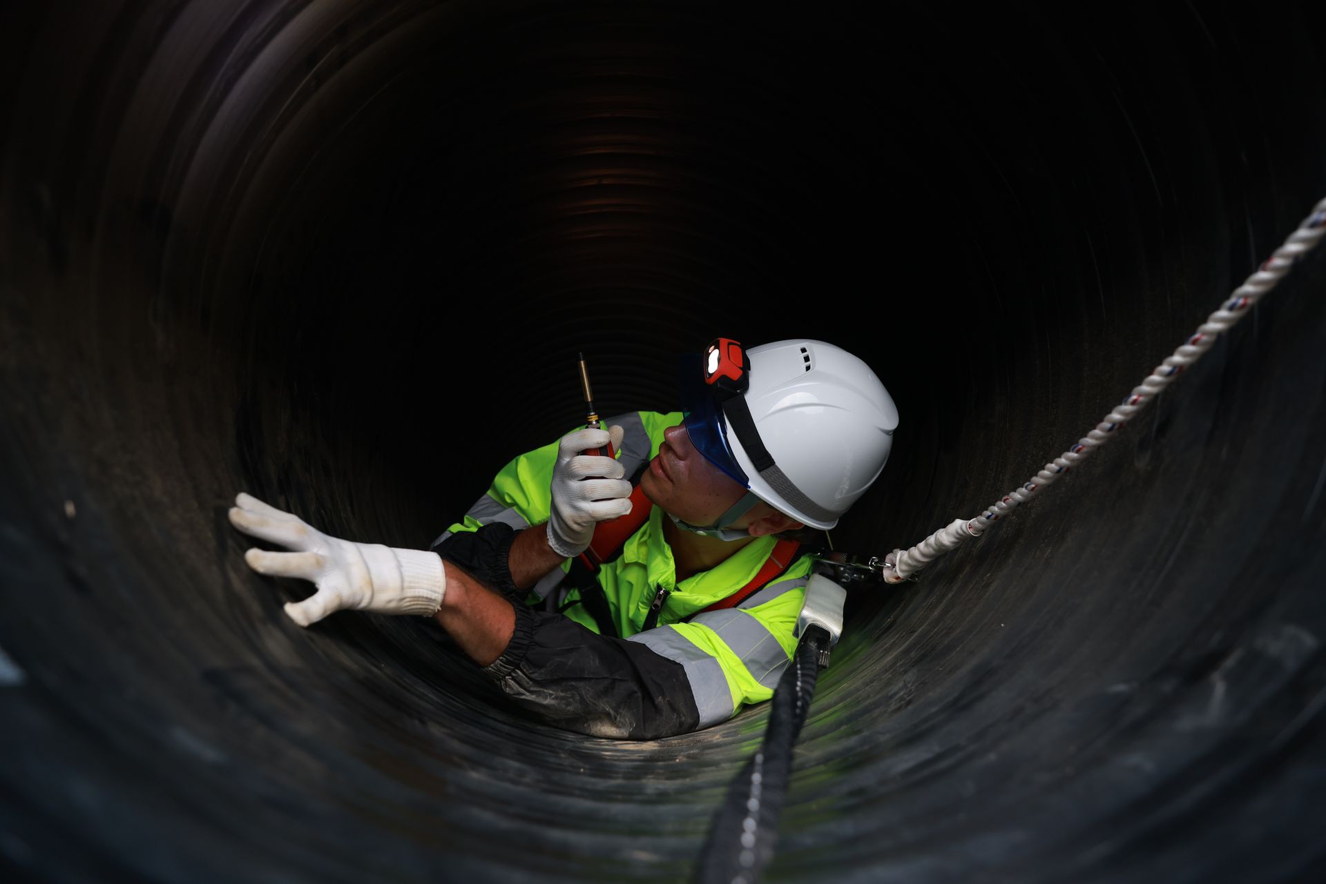 Checking construction pipeline work under a huge tube at the construction site.