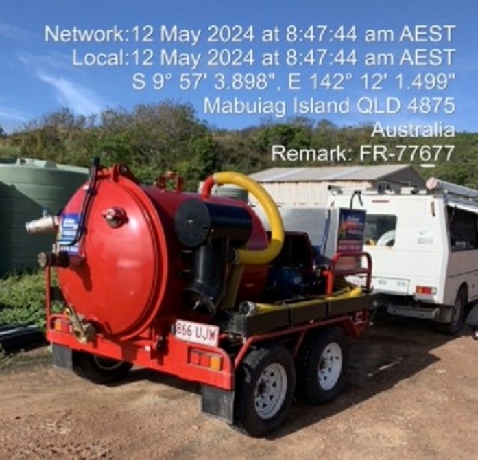 Red vacuum truck trailer on Mabuiag Island, Australia. Date/time/location stamps visible.
