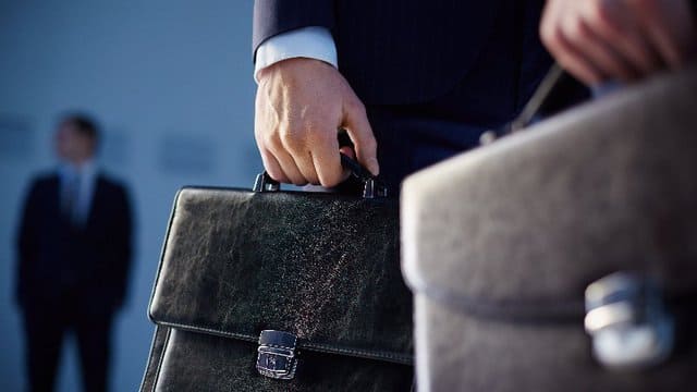 Ein Mann im Anzug hält eine Aktentasche in der Hand.