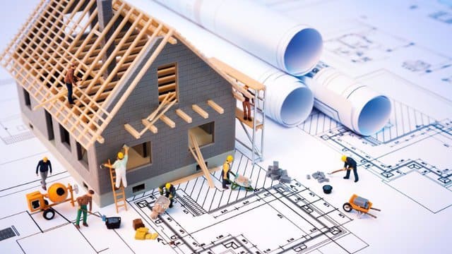 Auf Grundlage eines Bauplans wird ein Modellhaus gebaut.