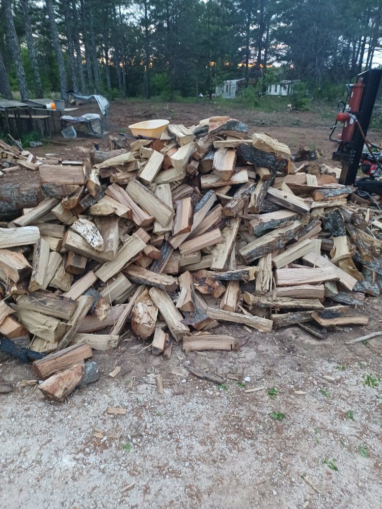A pile of wood is sitting on the ground in a field.