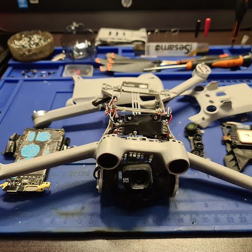 Un dron está sentado encima de una alfombra azul sobre una mesa.