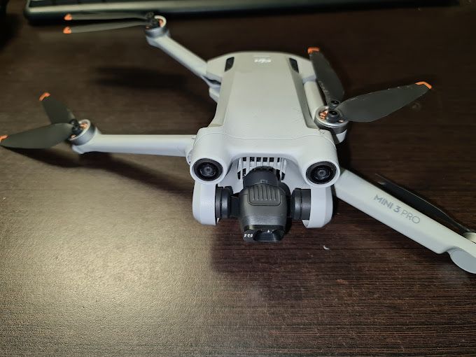 Un pequeño dron está sentado encima de una mesa de madera.