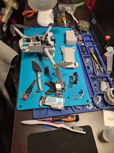 Un dron está sentado encima de una alfombra azul sobre una mesa.