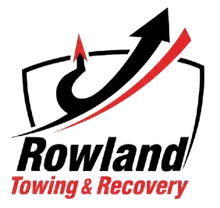 Logo for Rowland Towing & Recovery: black and red arrow over text in a shield.