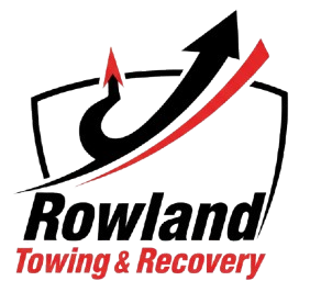 Logo for Rowland Towing & Recovery: black and red arrow over text in a shield.