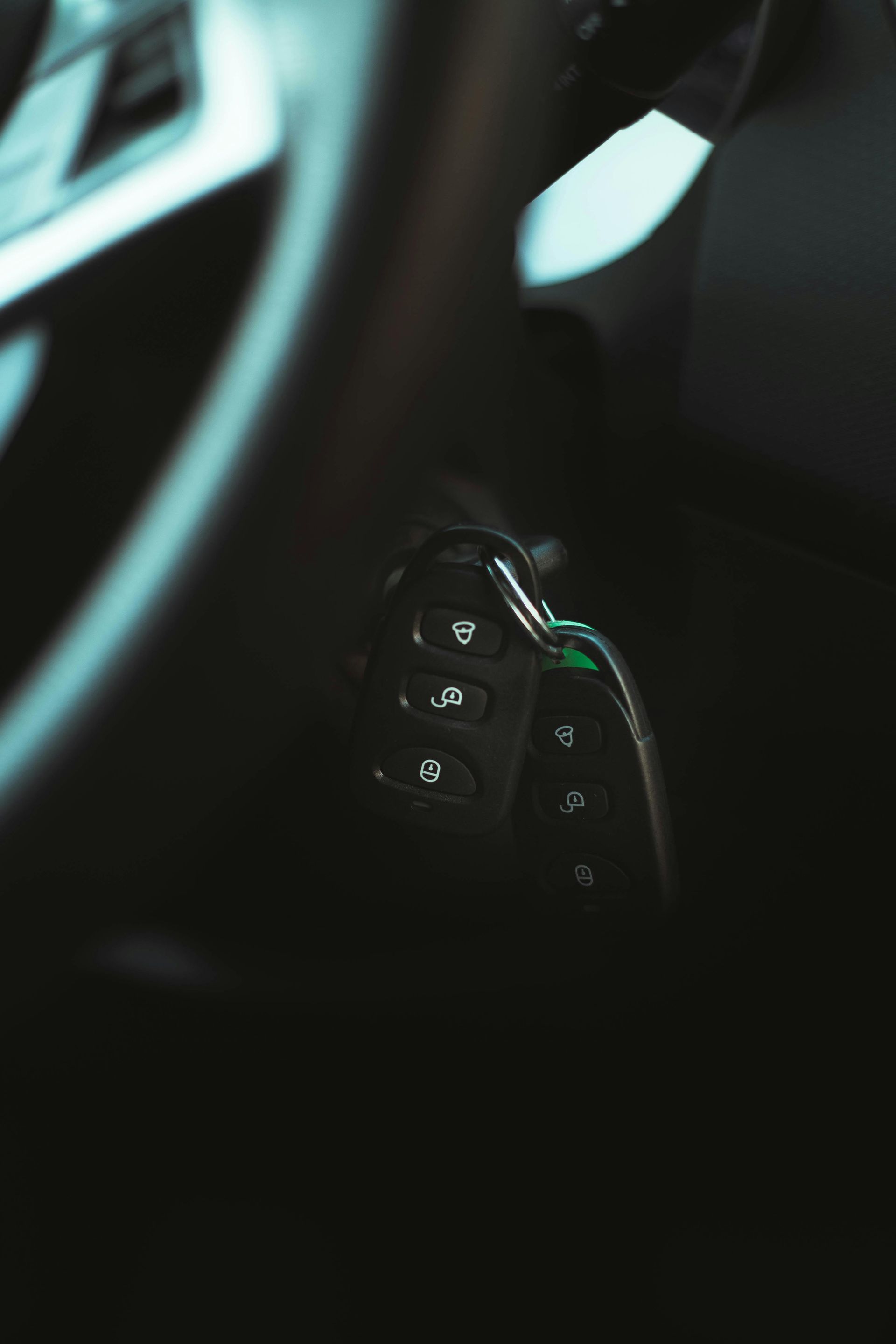 Close-up of car's steering wheel control panel with several buttons. Black and chrome details.