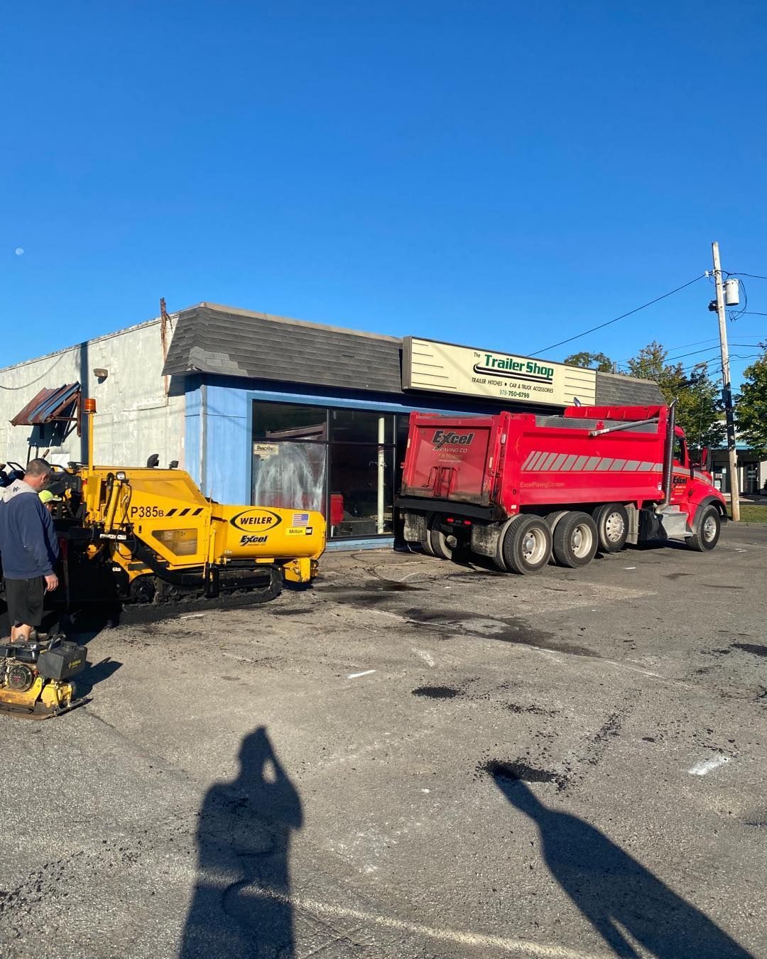 A red dump truck is parked in front of a building.