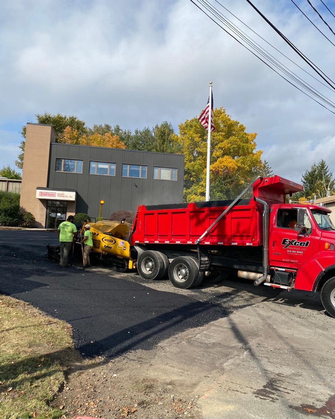 A red dump truck is parked in front of a building.