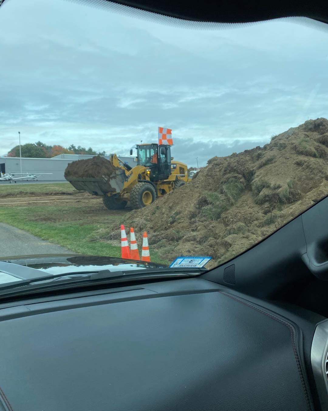 A bulldozer is digging a pile of dirt in a field.
