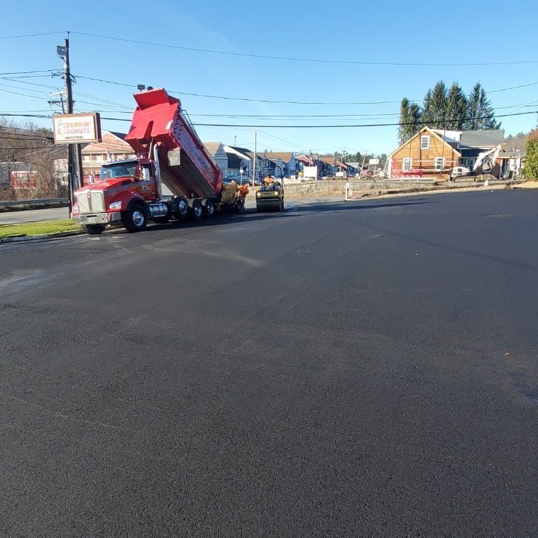 A red dump truck is parked on the side of the road