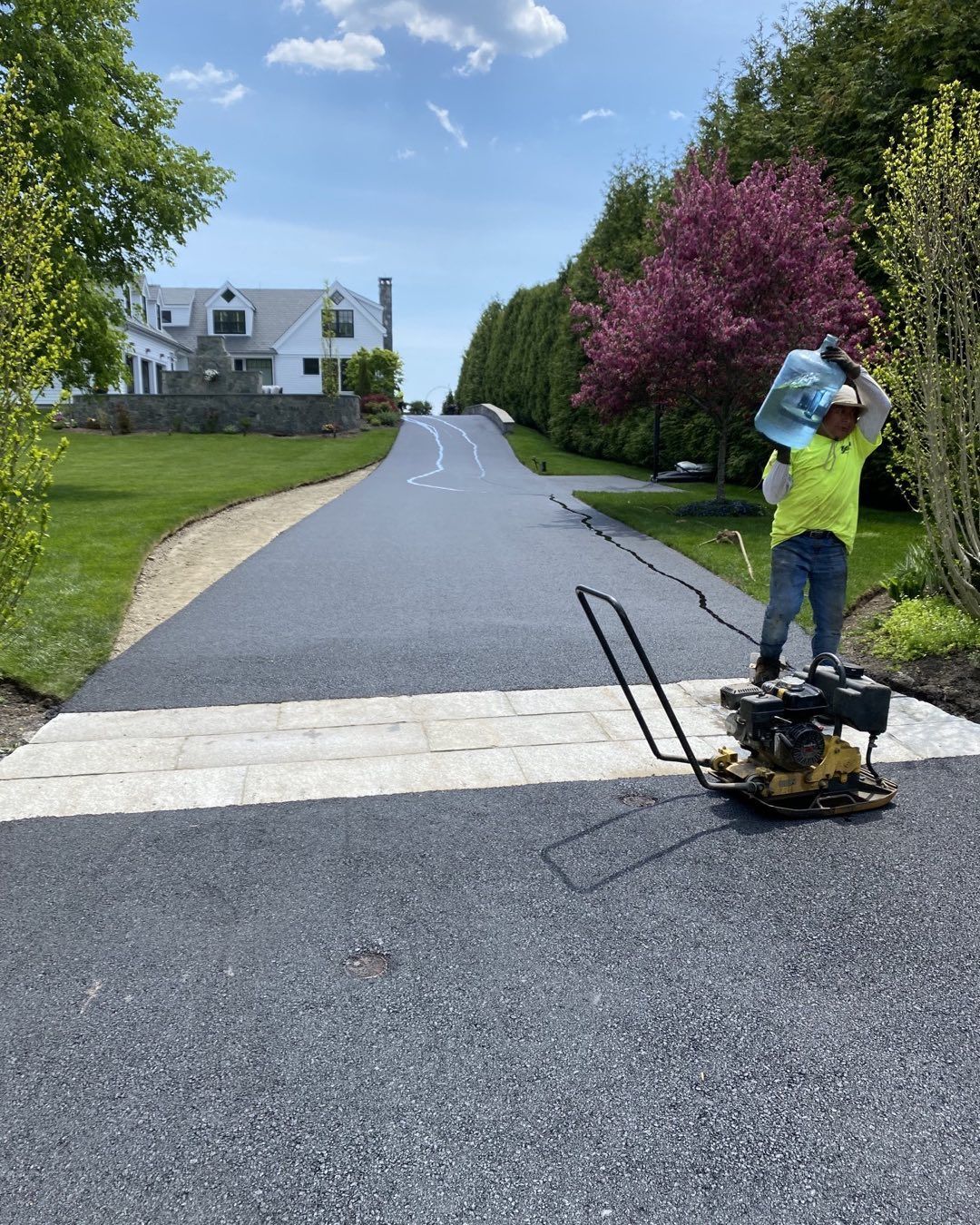 A man is standing on a machine on the side of a road.