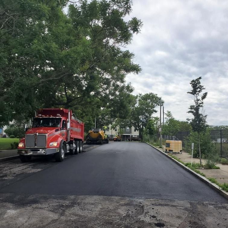 A red dump truck is parked on the side of the road
