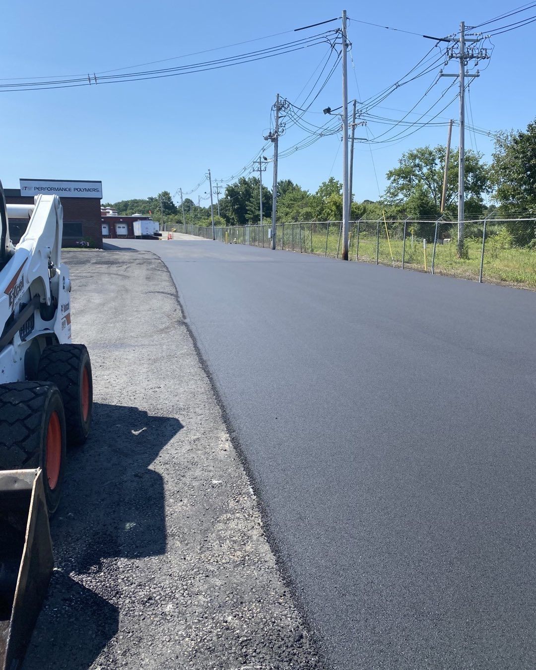 A bobcat is parked on the side of a road.