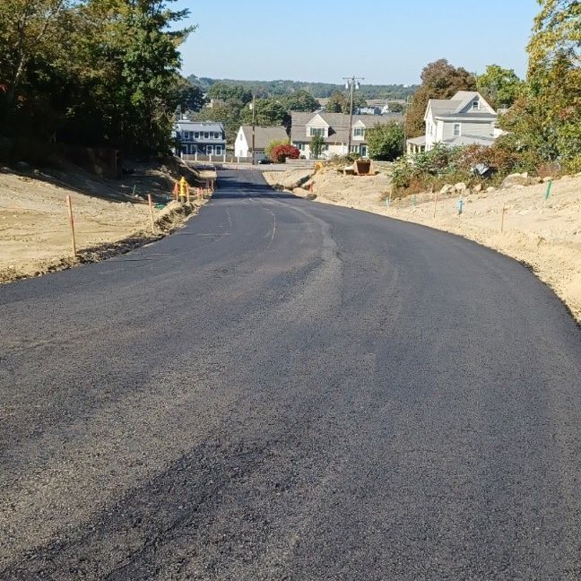 A road going through a residential area with houses in the background