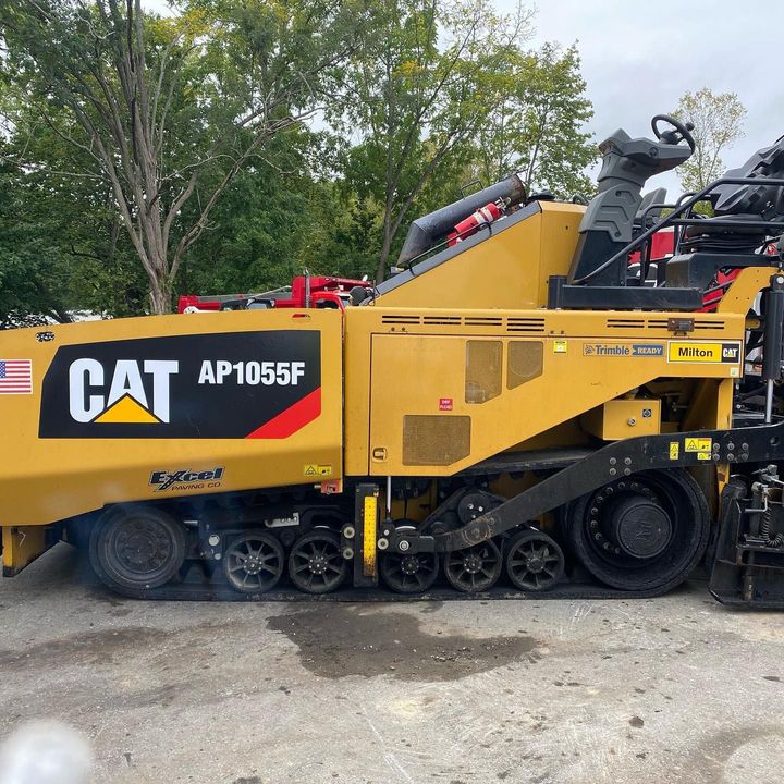 A cat asphalt paving machine is parked in a parking lot