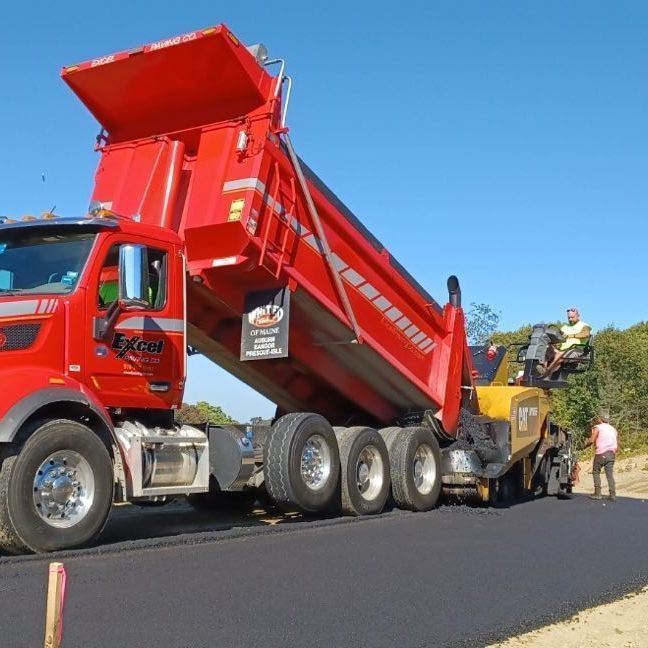 A red dump truck with the word kenworth on the side