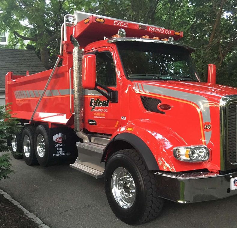 A red dump truck is parked on the side of the road