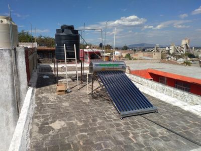 Un calentador de agua solar está en el techo de un edificio.
