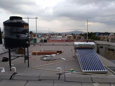 Un calentador de agua solar está en el techo de un edificio.