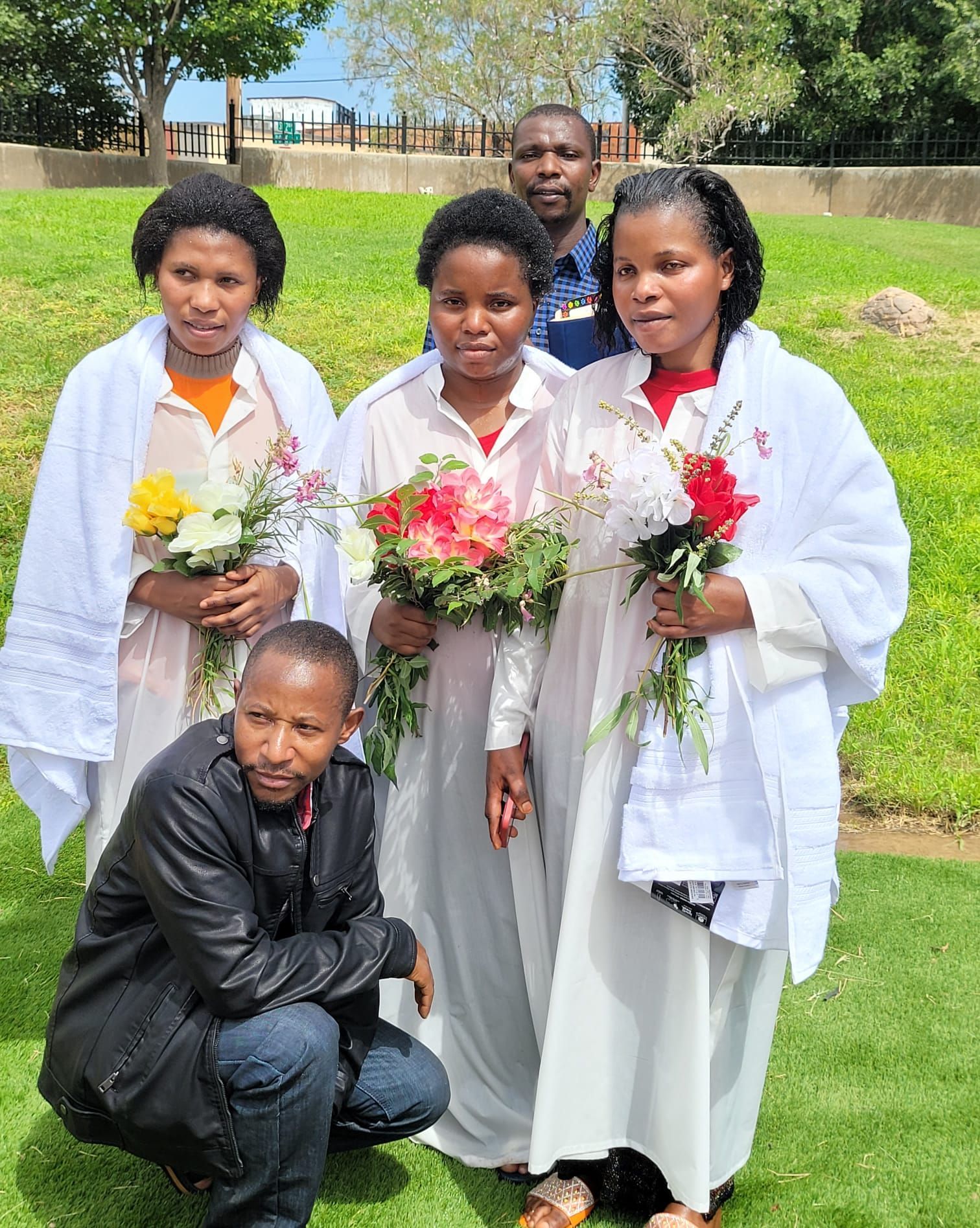 A man in a black suit is holding a bible