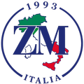 Logo ZMI Italia con mappa dell'Italia in verde, bianco e rosso, incorniciato da un cerchio blu con le scritte