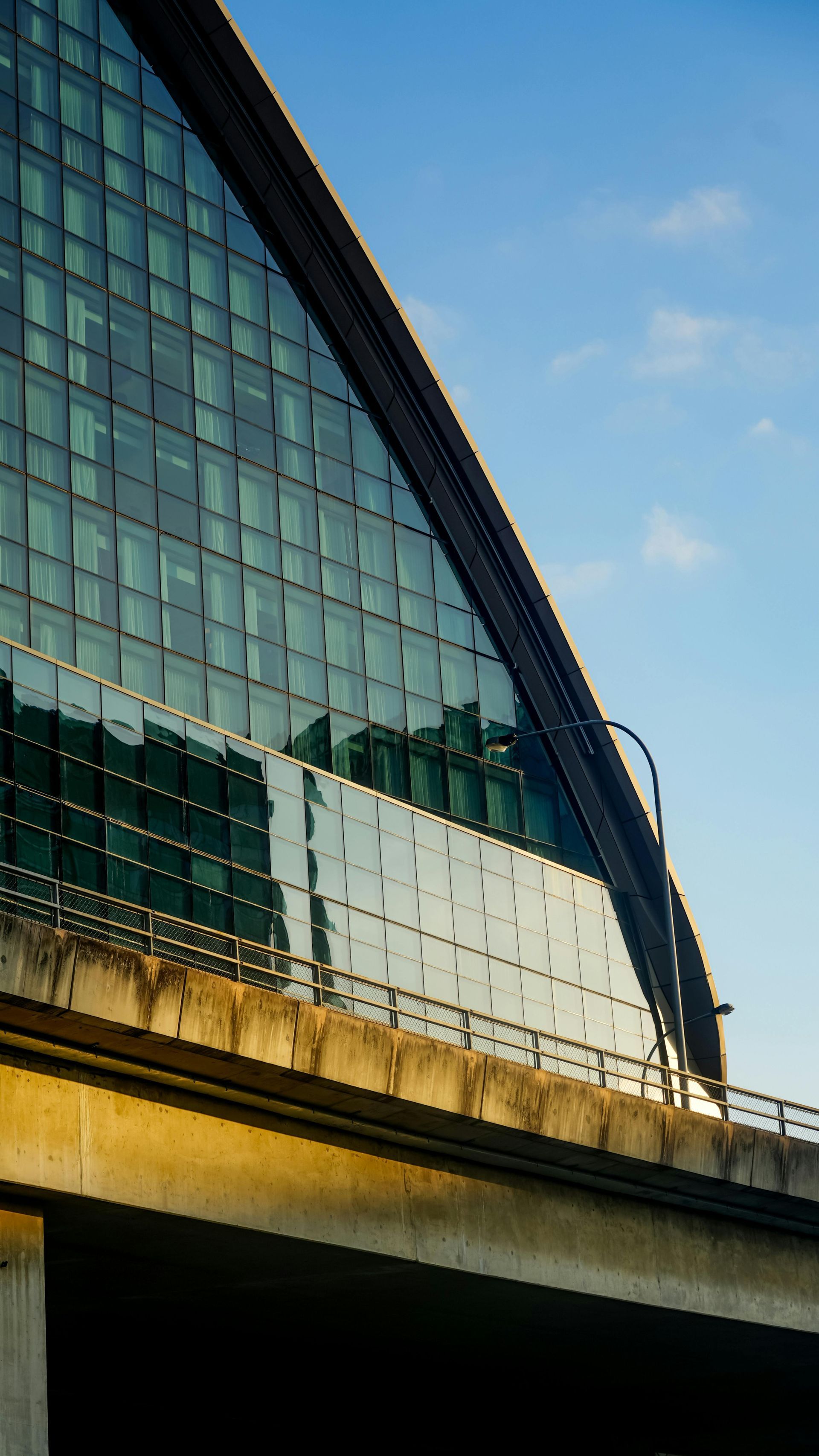 A building with a lot of windows and a bridge in the background