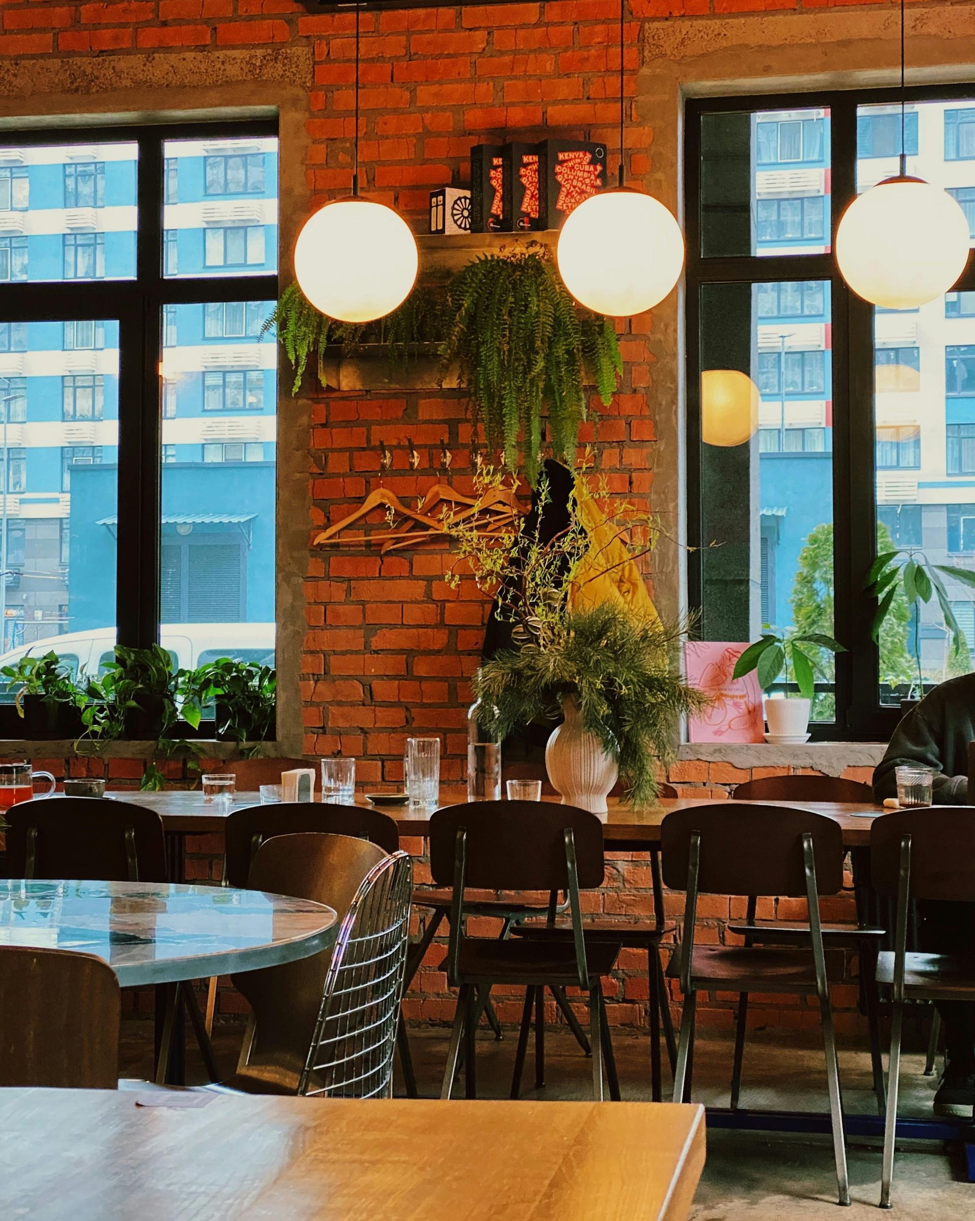 A restaurant with tables and chairs and a brick wall
