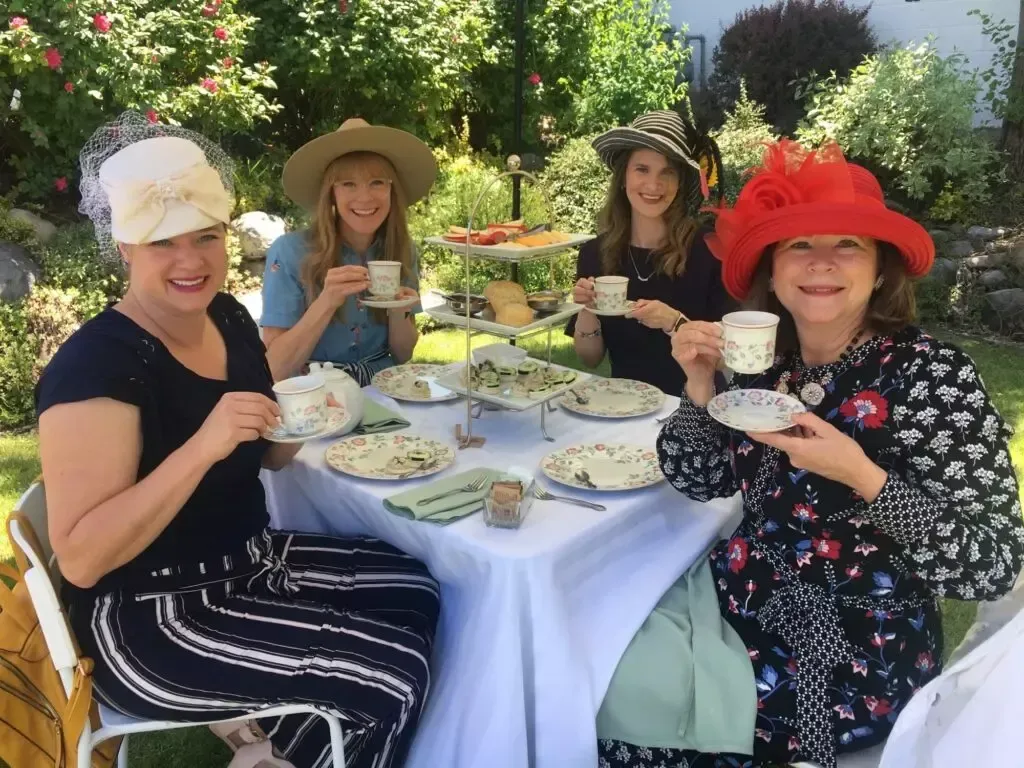 A group of women are sitting at a table drinking tea.