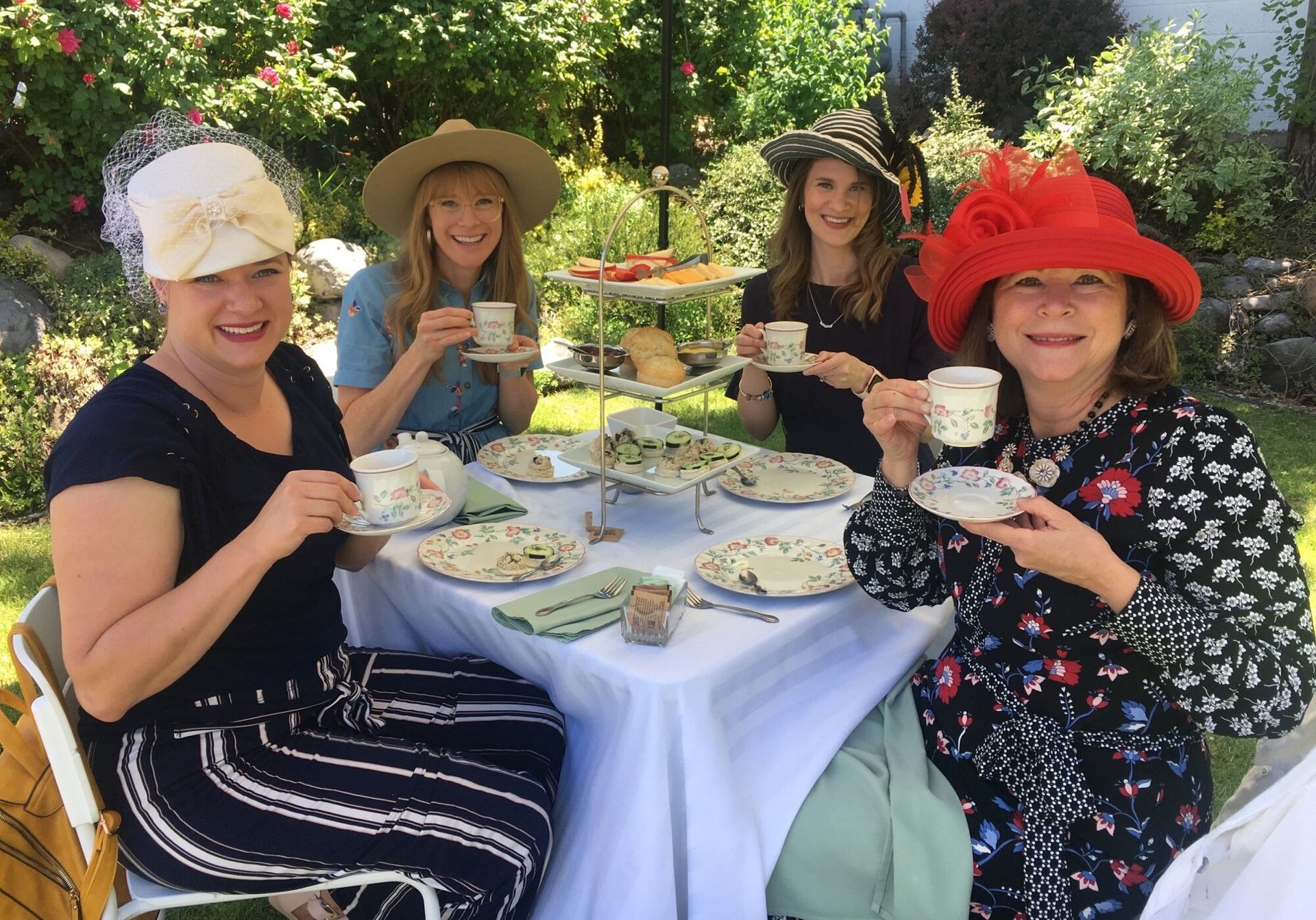 A group of women are sitting at a table drinking tea.