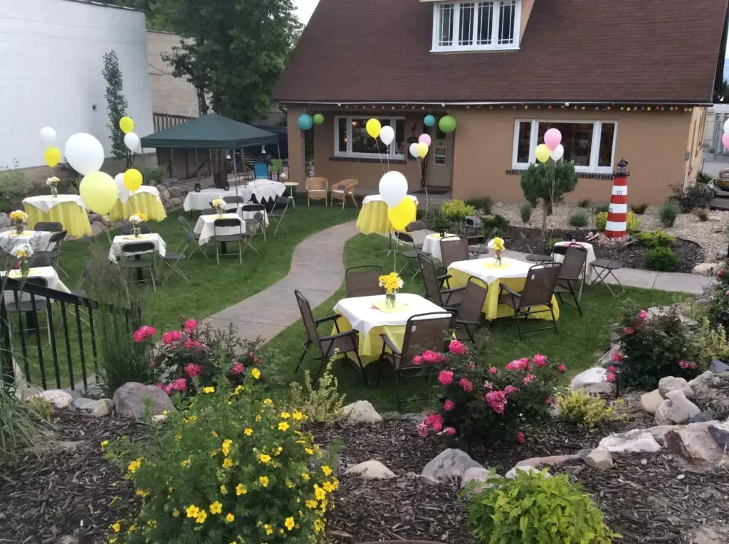 A house with tables and chairs set up in front of it