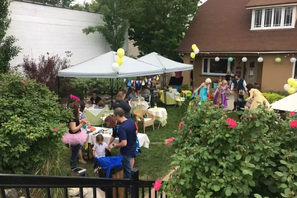 A group of people are having a party in the backyard of a house.