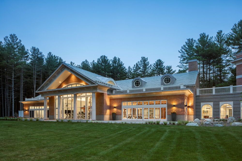 A large house with a lot of windows is surrounded by trees