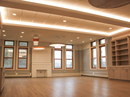 An empty room with a fireplace and lots of windows