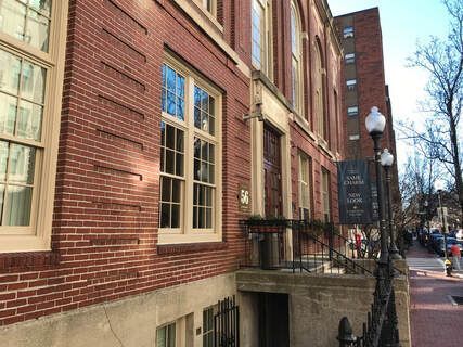 A large brick building with a lot of windows and stairs leading up to it.