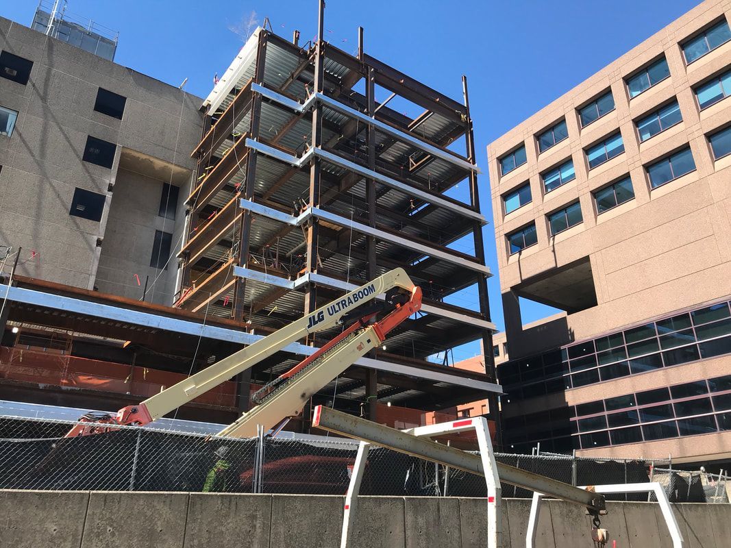 A large building under construction with a crane in front of it.