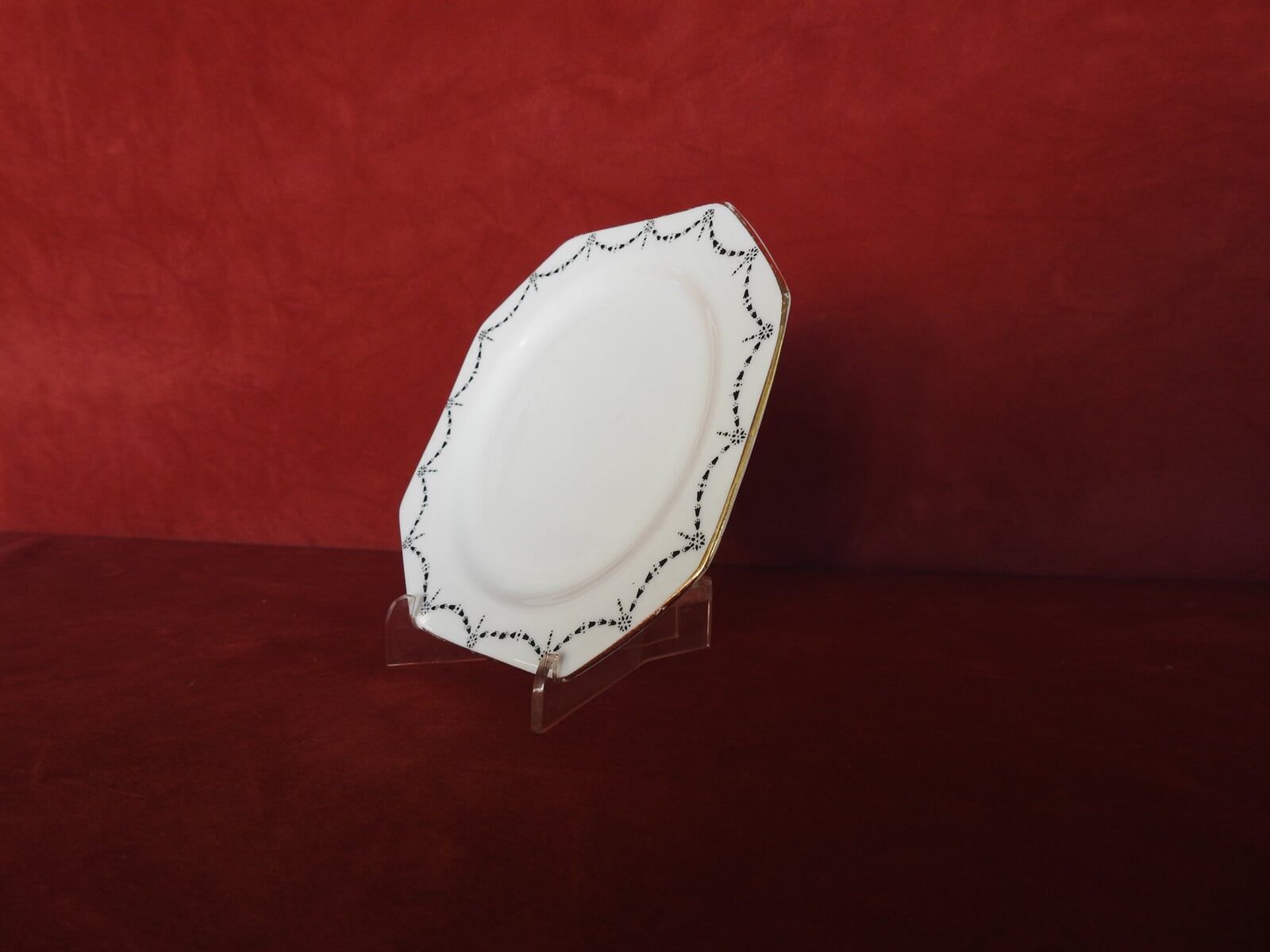 A White Plate Is Sitting On A Clear Stand On A Table — Light Industries in Bowral, NSW