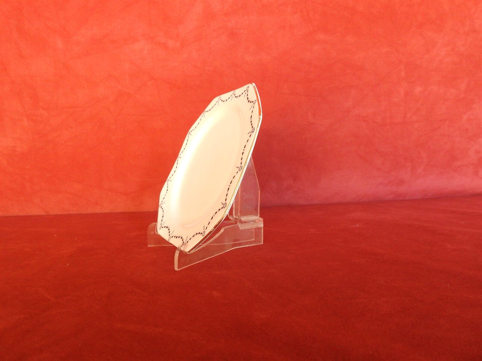 Side Left, A White Plate Is Sitting On A Clear Stand On A Red Table — Light Industries in Bowral, NSW