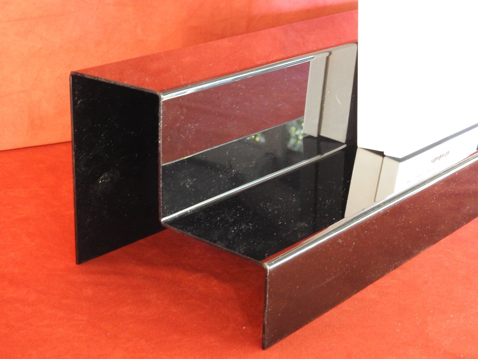 A Black Shelf Is Sitting On A Red Surface — Light Industries in Bowral, NSW