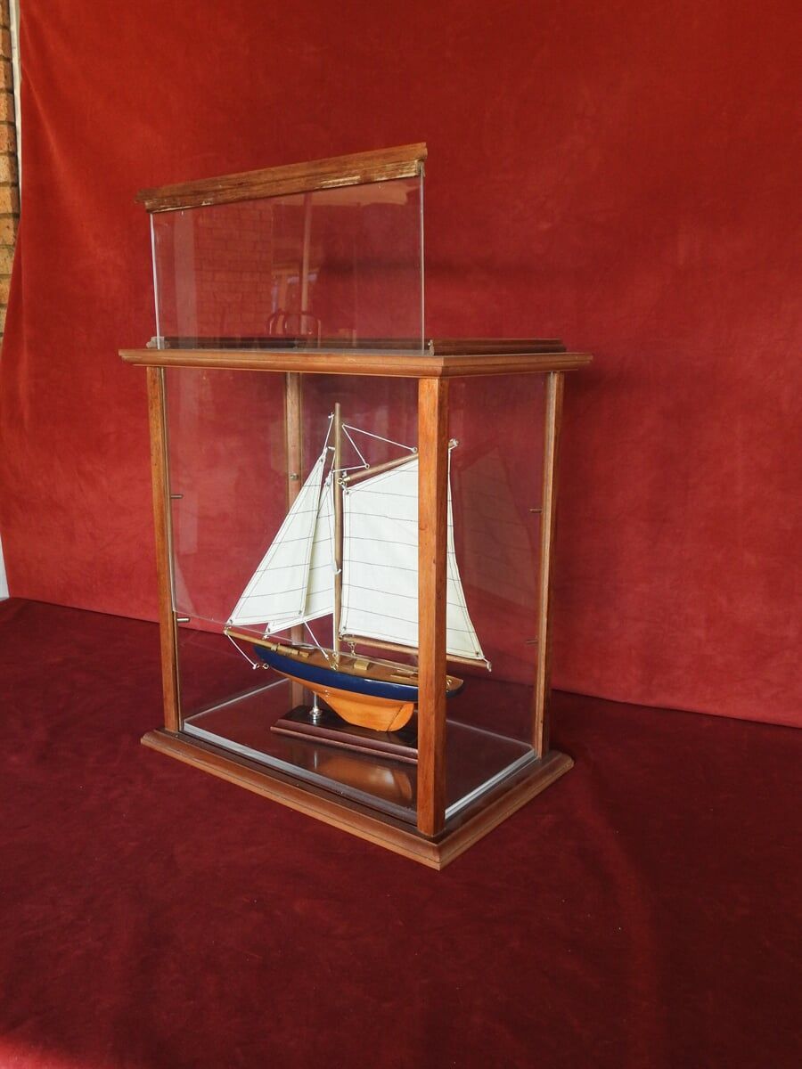 A Model Sailboat Is In A Glass Case On A Table — Light Industries in Bowral, NSW