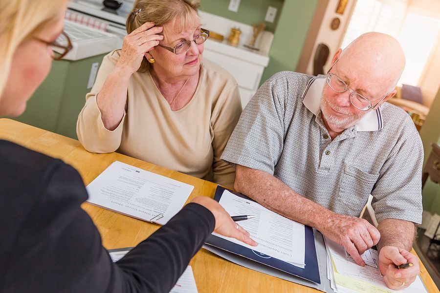 A man and a woman are sitting at a table signing papers.