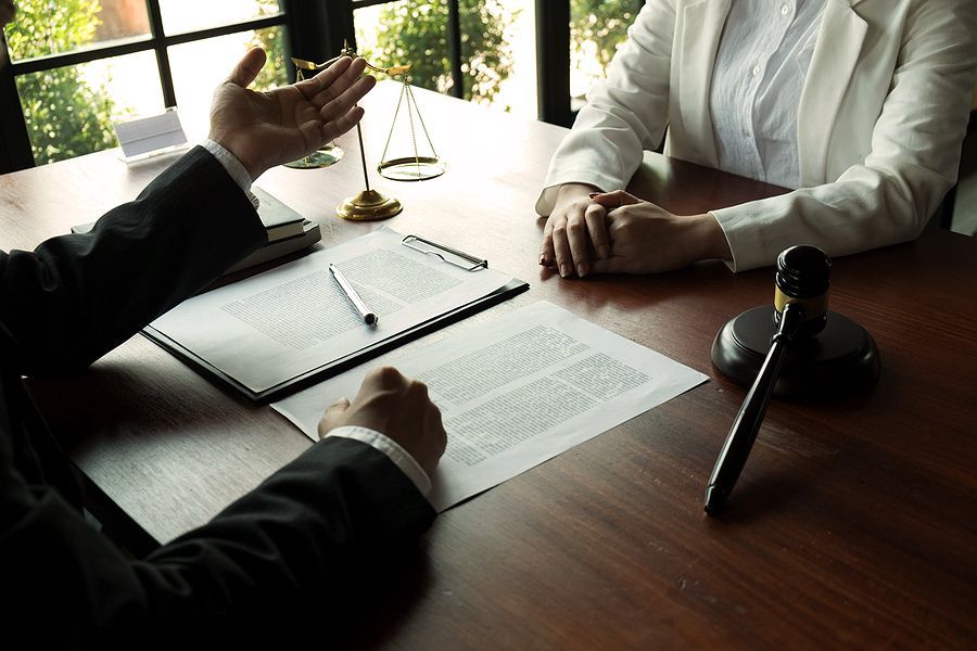 A man and a woman are sitting at a table with papers and a gavel.