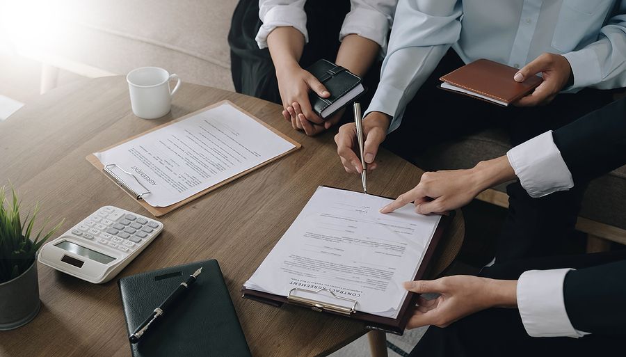 A group of people are sitting at a table signing a document.