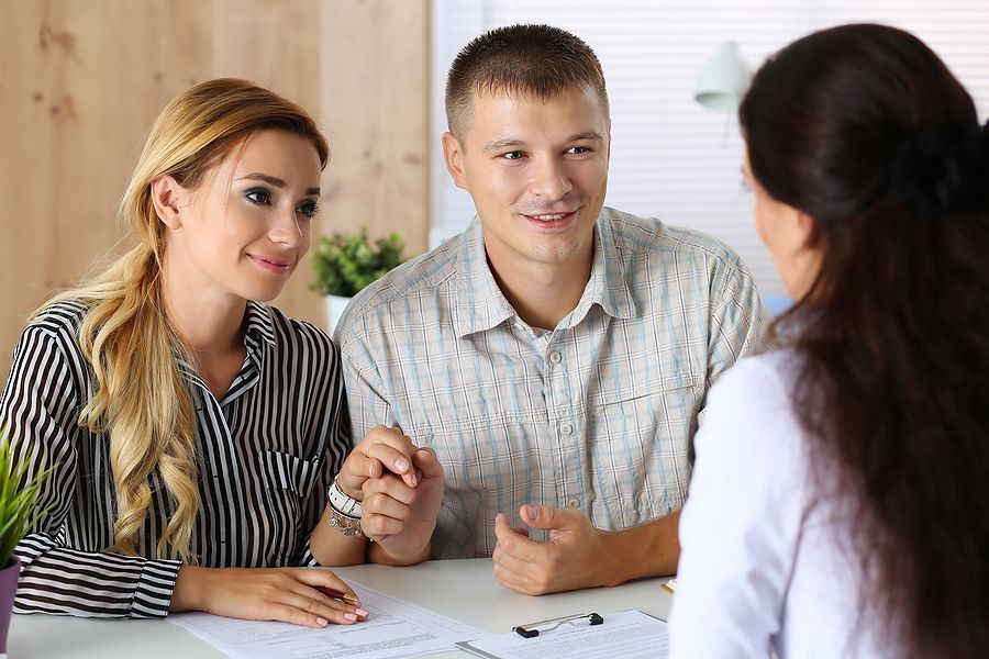 A man and a woman are sitting at a table talking to a doctor.
