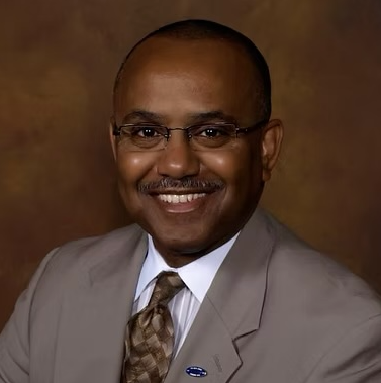 A man in a suit and tie is smiling for the camera
