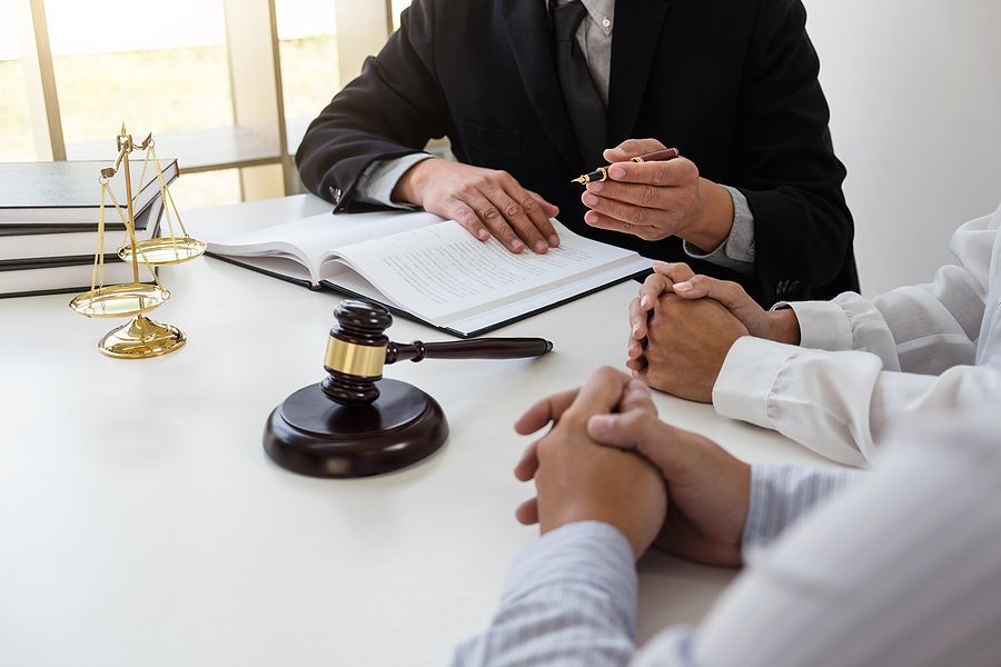 A group of people are sitting at a table with a judge.