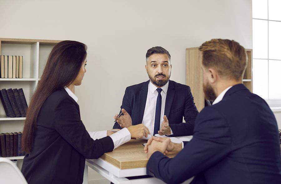 A group of business people are sitting at a table having a meeting.