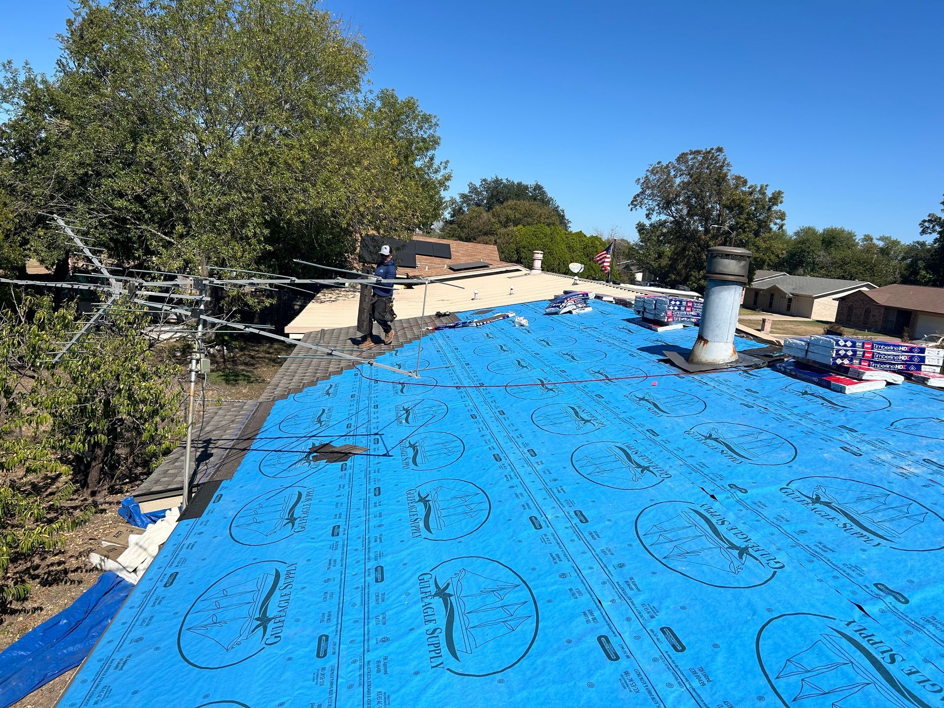A blue tarp is covering the roof of a house.
