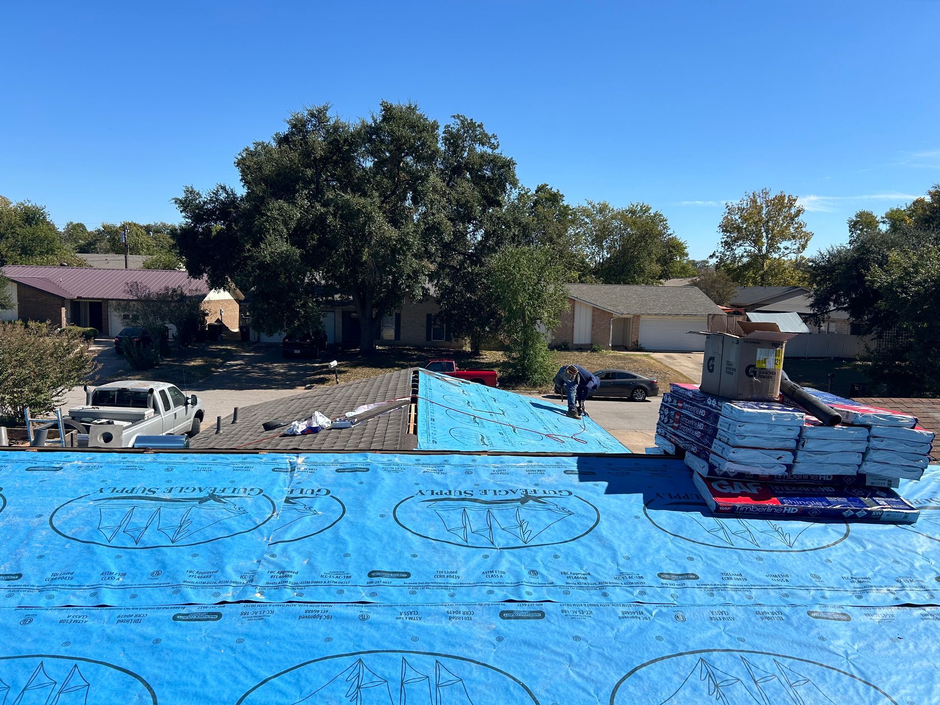 A blue tarp is covering the roof of a house.